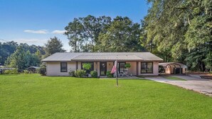 A single-story house with a metal roof, a front porch, and a well-maintained lawn. - Quality comfort in a convenient location (entire house) (Beaufort)