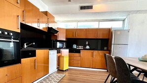 Una cocina moderna con armarios de madera, un horno negro, un microondas y un refrigerador.