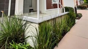 A modern two-story residential building with a balcony and a small porch. - Frank's Pismo Beach House: Steps to Sand & Surf (Pismo Beach)
