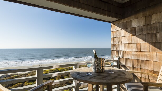 A wooden deck with a table and chairs overlooking the ocean. - Oceanfront 3BR/3Bath Premier Penthouse in the heart of Kiawah (Kiawah Island)