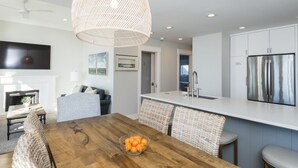 A modern kitchen with a central island, white cabinetry, and a stainless steel refrigerator. - Oceanfront 3BR/3Bath Premier Penthouse in the heart of Kiawah (Kiawah Island)