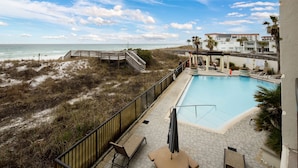 A pool area with a view of the beach and ocean, a wooden deck, and lounge chairs. - BR 108: Golden Horizon - Indulge in the Ultimate Beachfront Escape! 2nd level (Fort Walton Beach)