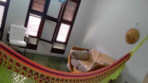 A room with a hammock, a chair, and a bed. - conceitual hostel natal (Natal)