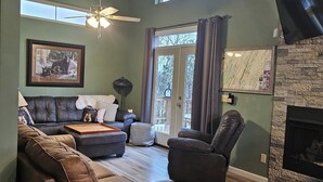 A spacious living room with a fireplace, leather sofas, a ceiling fan, and large windows. -  2 bd 2bth, Thomas, WV, near Canaan and Davis, WV skiing, trails, State Parks  (Thomas)