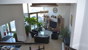 A spacious living area with a large window, a fireplace, and a television.