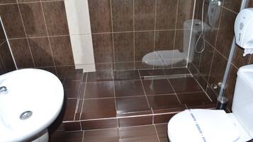 Un baño con lavamanos, inodoro y ducha.