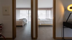 Une chambre d’hôtel avec deux lits, une table de chevet, une lampe et un extincteur.