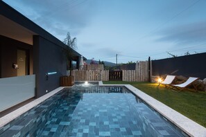 A modern outdoor swimming pool with a clear view of the surrounding area, including a wooden fence and lounge chairs. - Abraços dos Avós - Casas de Aldeia  (Viana do Castelo)