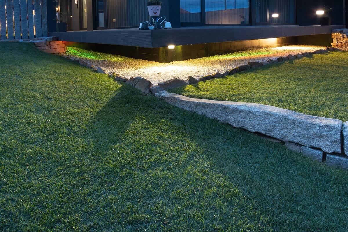 A modern house with a flat roof, large windows, and a well-lit porch area.