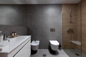 A modern bathroom with a large sink, bidet, and shower. - Abraços dos Avós - Casas de Aldeia  (Viana do Castelo)