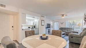 A spacious living room with a round table, a sofa, and a dining area. - Spacious Split Floor Plan with Pool and Mountain views (Tucson)