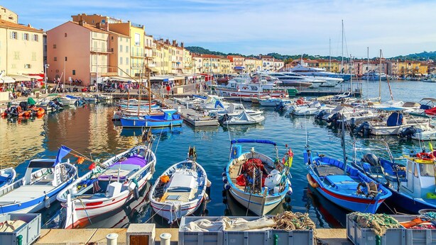 A marina with various boats docked, surrounded by buildings.