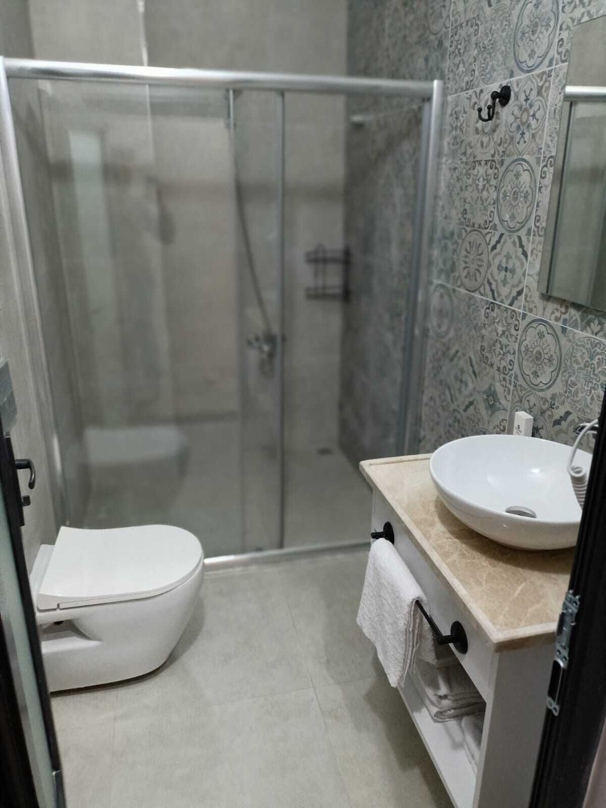 Un bagno con il water, un lavandino e uno spazio doccia.