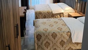 A hotel room with two beds, a desk, and a view of the sea through large windows. - The Marine Hotel  (Arsin)