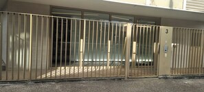 A gated entrance with a number '3' sign, a metal gate, and a building facade with windows. - New condo, Quiet, Bright, Terrace, Free Parking (Romainville)