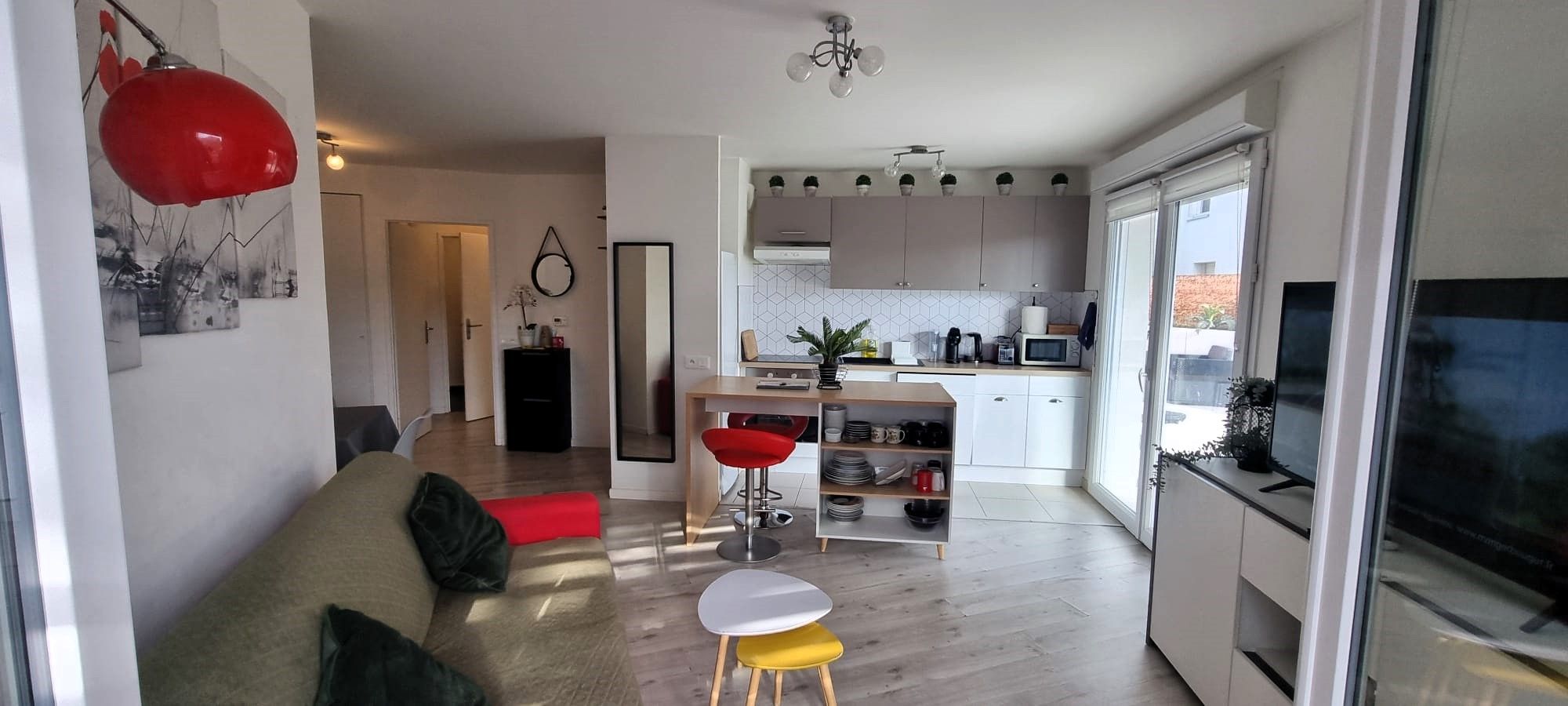 Un appartement moderne comprenant un salon, une cuisine et un coin repas.