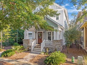 A two-story house with a front porch, stone foundation, and a mailbox.