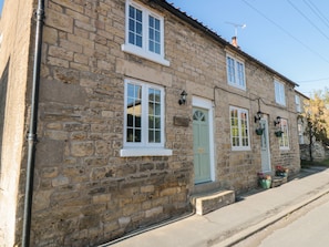 A stone building with a green door, white-framed windows, and a sign reading "Apple Tree Cottage." - Appletree Cottage (Scarborough)