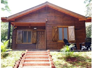 Cozy cabin with a gabled roof and a welcoming front porch.
