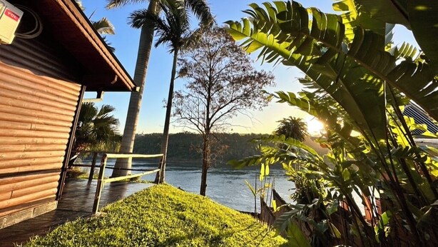 Un edificio de madera con vistas a un lago y palmeras.