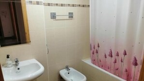 Un baño con lavamanos, bidé e inodoro.