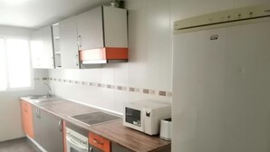 Una cocina equipada con microondas, tostadora y refrigerador.