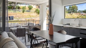 A modern kitchen with a large window, a dining area with a table and chairs, and a view of the outdoors. - Contemporary 3-Bedroom in Bo-Kaap | Views and Pool (Cape Town)