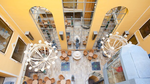 A spacious atrium with high ceilings, large windows, and a central open area with tables and chairs. - Mix Peymar (Sant Llorenc des Cardassar)