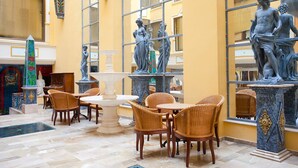 A spacious lobby with a fountain, wicker chairs, and classical statues. - Mix Peymar (Sant Llorenc des Cardassar)