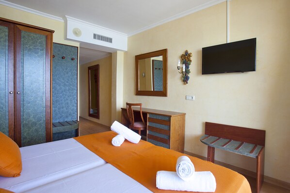 A hotel room with a bed, a desk, a chair, a bench, a television, and a wardrobe. - Mix Peymar (Sant Llorenc des Cardassar)
