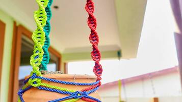 A hanging pot with colorful ropes.