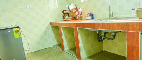 A kitchen with a countertop, sink, and a refrigerator.