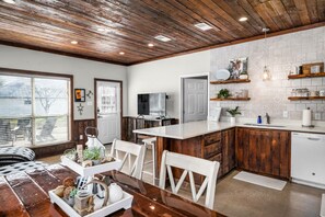 Une cuisine moderne avec des meubles en bois, un plan de travail blanc et un lave-vaisselle encastré.