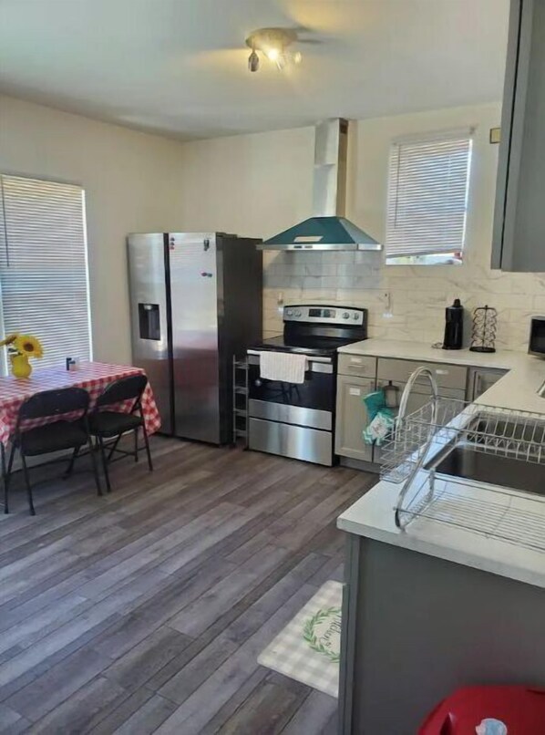 A compact kitchen with a refrigerator, stove, and sink.