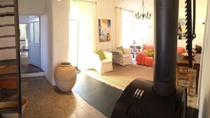 Eine Treppe führt zu einem Wohnzimmer mit einer Couch, einer großen Vase und einem schwarzen Heizkörper.