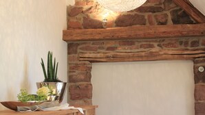 A rustic interior with a stone fireplace, wooden beams, and a metal bowl with plants. - Exclusive, high-end ***** vacation rental with a large garden (Freiamt)