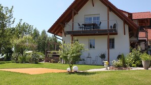 A two-story house with a balcony, surrounded by a well-maintained garden and a wooden deck. - Exclusive, high-end ***** vacation rental with a large garden (Freiamt)