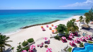 A beach resort with a pool, sun loungers, and umbrellas. - Concierge Collection at O2 Beach Club & Spa by Ocean Hotels (St. Lawrence Gap)