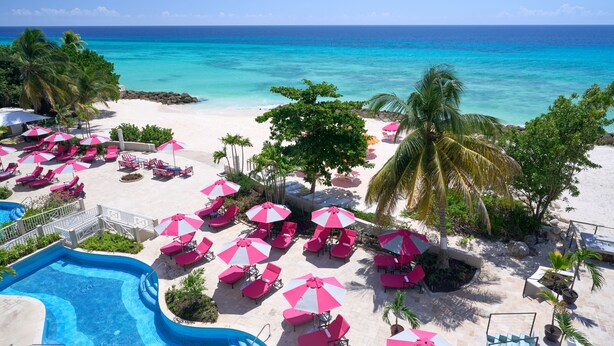 A resort with a pool, beach chairs, umbrellas, and a view of the ocean. - Concierge Collection at O2 Beach Club & Spa by Ocean Hotels (St. Lawrence Gap)