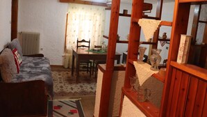 Una sala acogedora con un sofá, una mesa de comedor y una separador de madera.