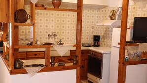 Una cocina con armarios de madera, una estufa y un refrigerador.