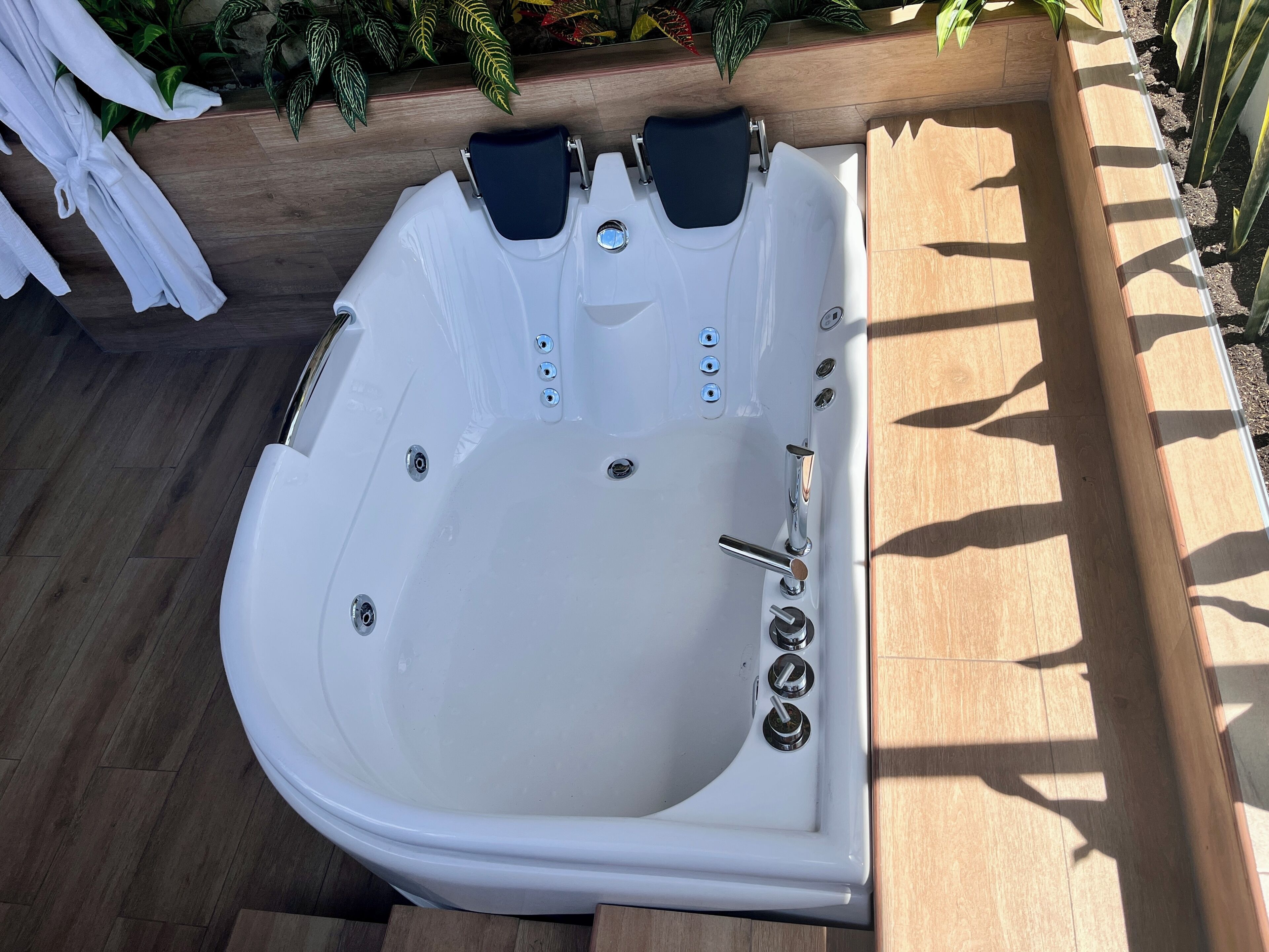 Un bain à remous équipé d’un panneau de commande, de deux sièges et d’un drain.
