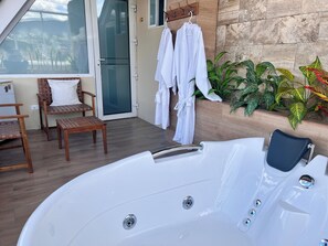 A spa area with a hot tub, wooden furniture, and potted plants. - CASA HIDALGO ECUADOR (Cumbayá)