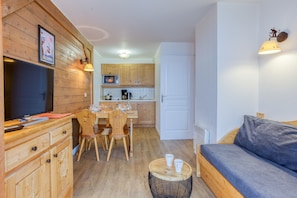 A compact living space with a kitchenette, a dining area, and a seating area.