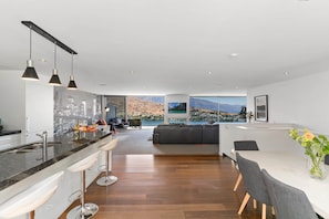 Una cocina moderna con barra, una mesa de comedor con sillas y vistas a un paisaje montañoso.