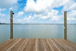 Un muelle de madera que se adentra en aguas tranquilas bajo un cielo despejado.
