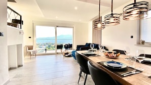Un comedor con vistas a la ciudad, una mesa de madera para cuatro personas y modernas lámparas colgantes.