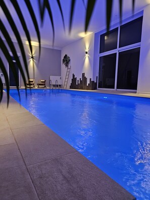 Relax by the rectangular pool surrounded by a tiled floor and lounge chairs.