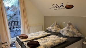 A bedroom with a bed, pillows, and a window with curtains.
