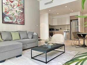 Appartement Deluxe | Coin séjour | TV connectée de 55 pouces avec chaînes par câble, télévision